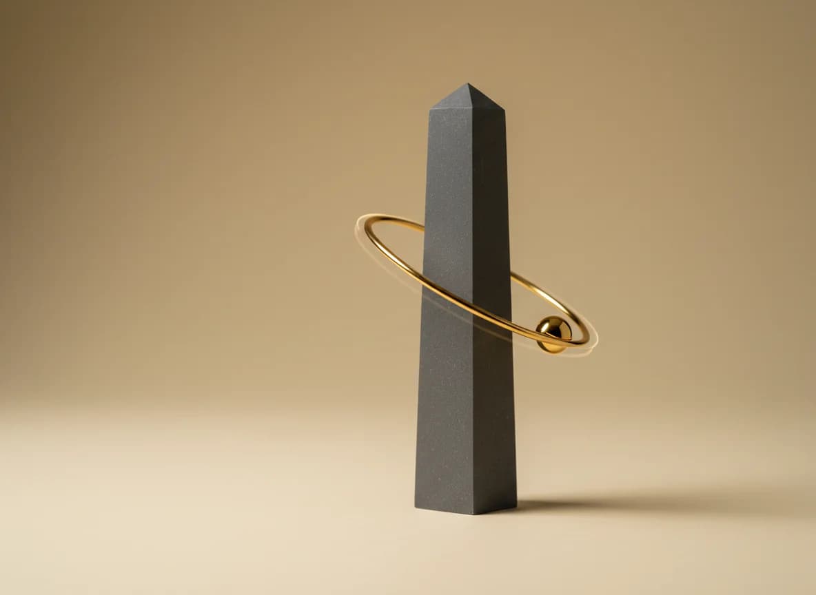 A graphite obelisk with a thin gold ring around it and a gold sphere riding the ring