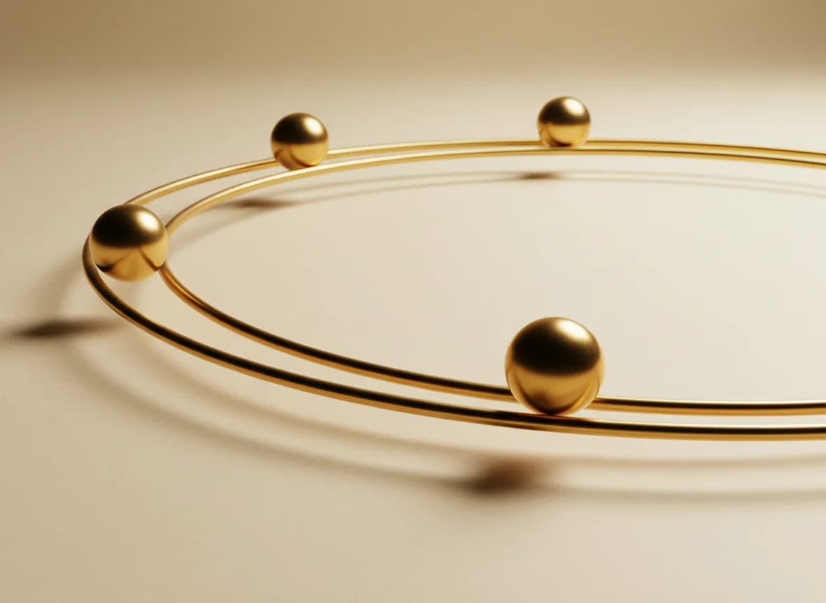 A polished gold rail forming a loop with three gold spheres travelling around it